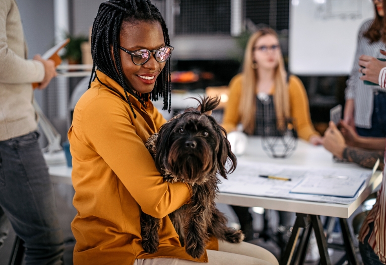 Woman holding a dog at work.
