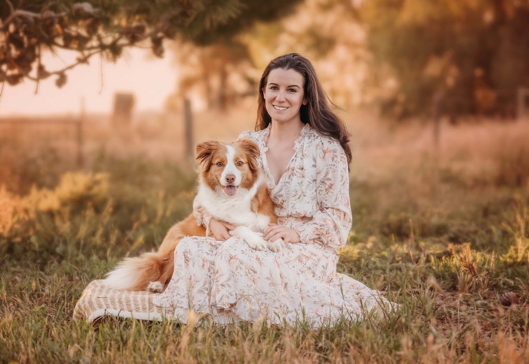 Sarina and her dog Flexi sitting on the grass.