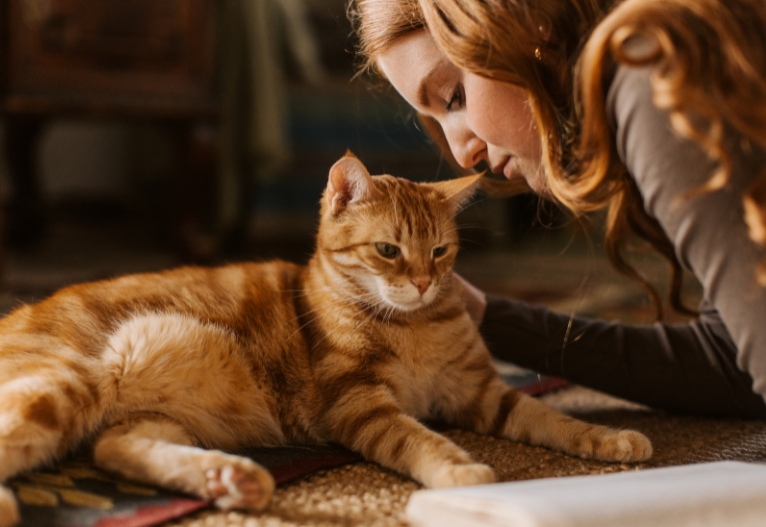 Red-headed woman with a ginger cat.