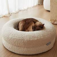 Cat sleeping in a round boucle cat bed.