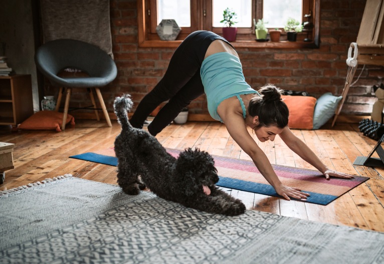 Woman doing yoga with her dog.