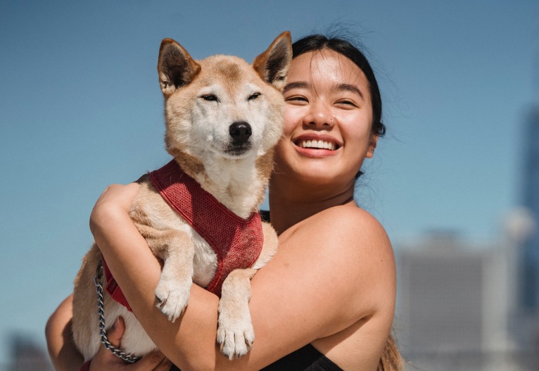 Woman smiling as she holds her dog.