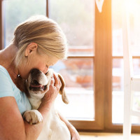 Elderly woman hugging a labrador.
