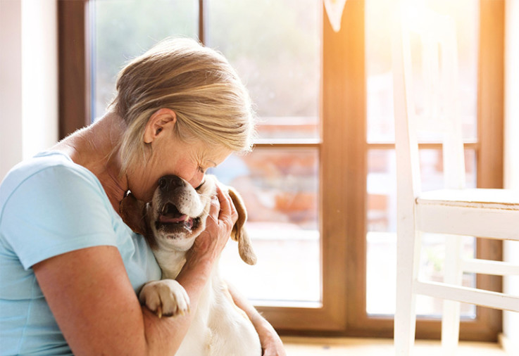 Elderly woman hugging a labrador.