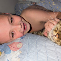 Nacey and his rescue cat Rocky lying in bed.