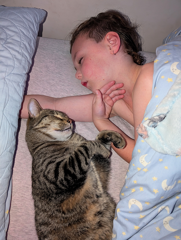 Nacey and his cat Rocky asleep in bed.