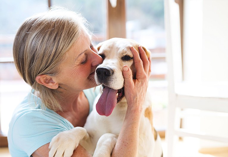 Woman hugging her happy dog.