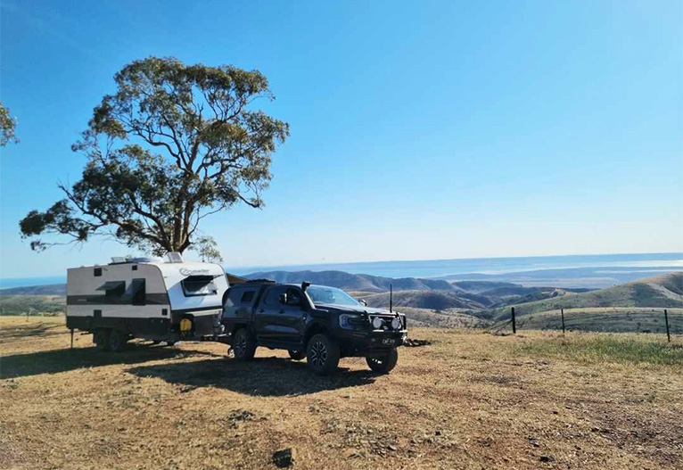Car towing a Crusader Caravan Musketeer Palace.