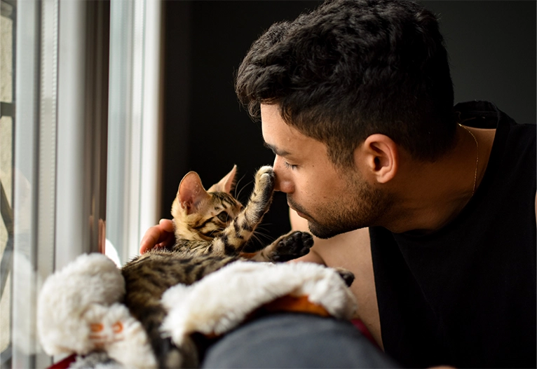 Man playing with his pet cat.