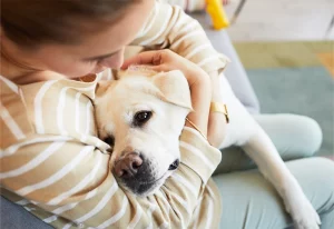 Woman hugging her pet dog.